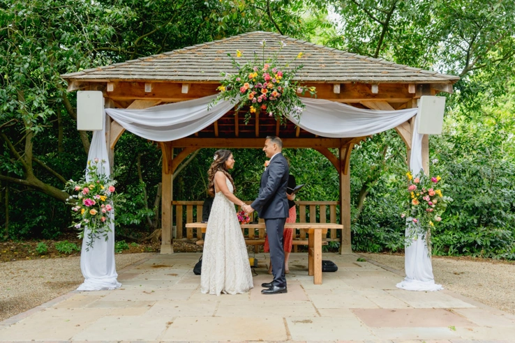 A bride and groom saying their vows under the gazebo of the Outdoor Ceremony Garden. 