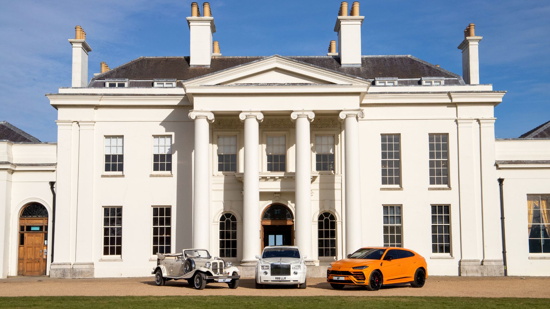 Fancy cars parked outside Hylands House. 