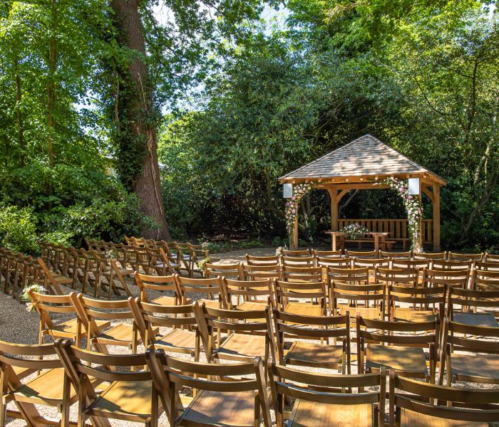 The gazebo of the Outdoor Ceremony Garden decorated with pink and white flowers. 