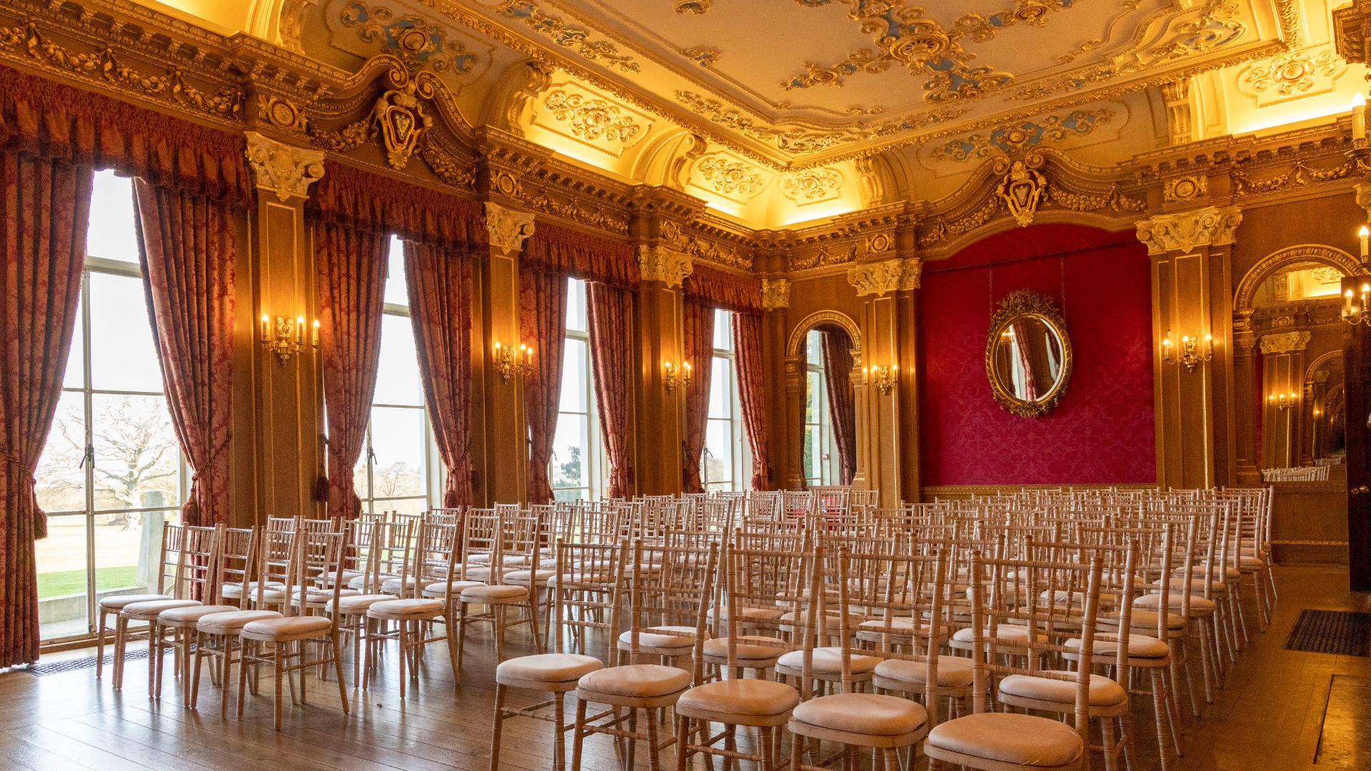 The banqueting room featuring red wallpaper and gold accents. 
