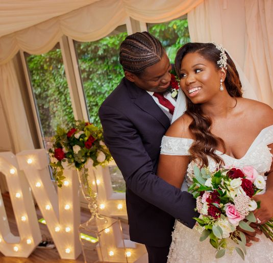 A groom with his arms around his bride. 