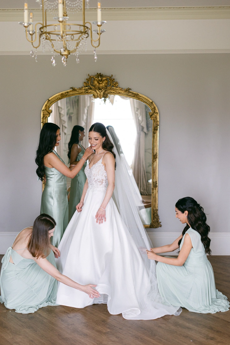 Bridesmaids helping to get the bride's dress looking nice. 