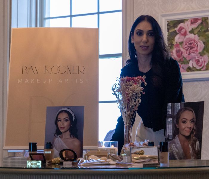 A makeup artist standing at her showcase table. 