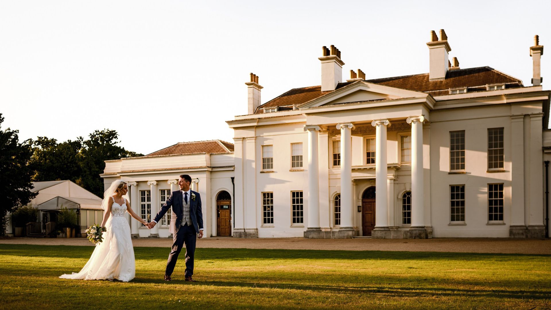 A couple walking hand-in-hand outside Hylands House. 