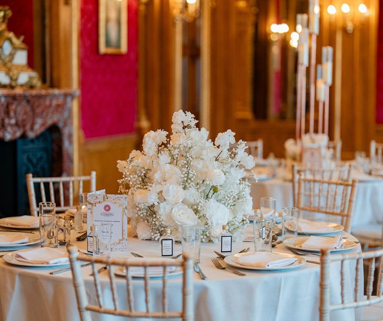 A close up of a round dining table in the Banqueting Room set with a white floral centrepiece. 