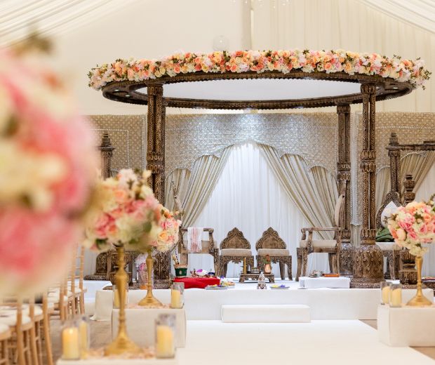 A Mandap decorated with light pink florals. 
